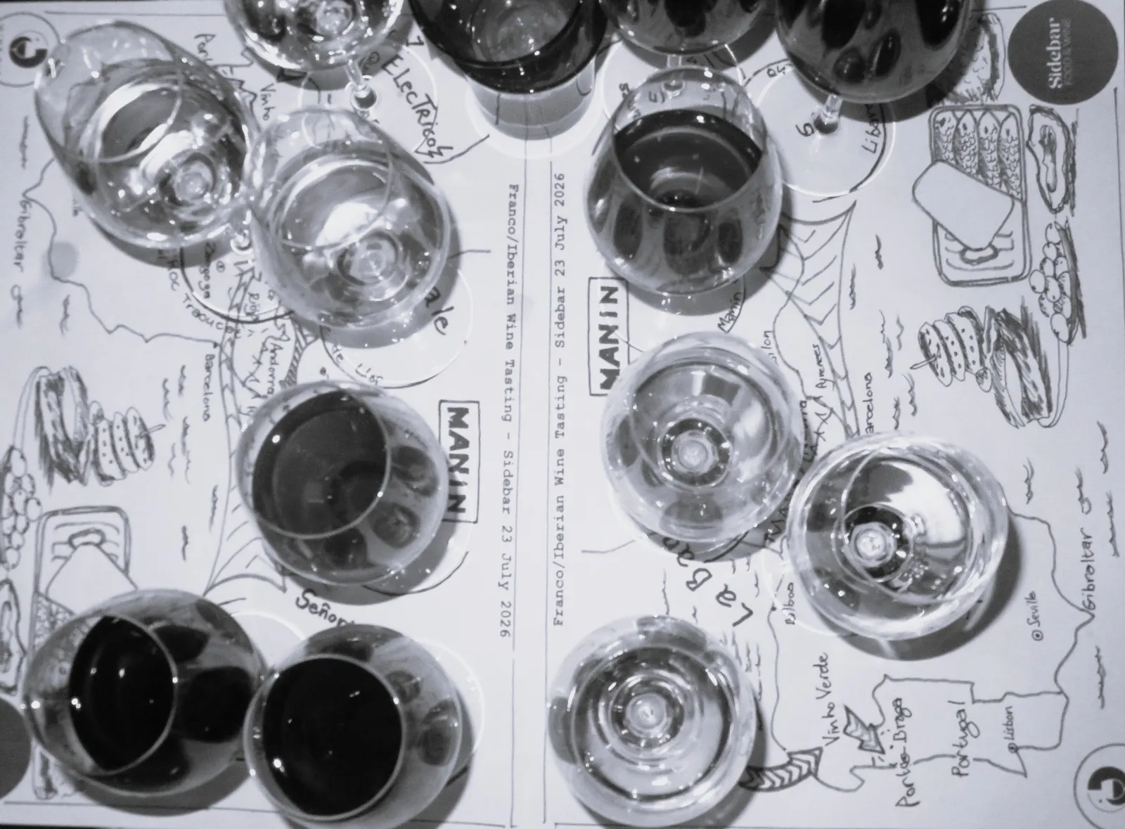 Wine glasses, bottles and hand-drawn tasting cards viewed from above